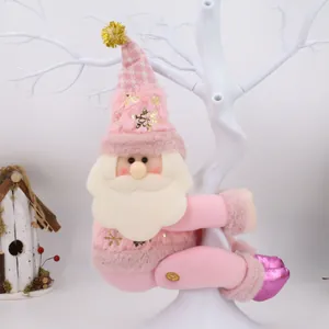 Dettaglio fermatenda in peluche di Babbo Natale rosa su un ramo bianco decorativo.