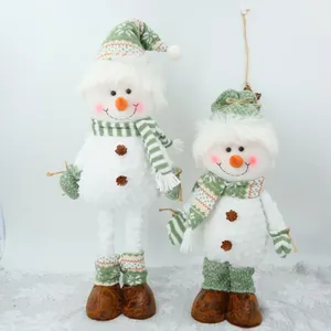 Vue détaillée de deux bonhommes de neige de Noël en peluche avec accessoires verts