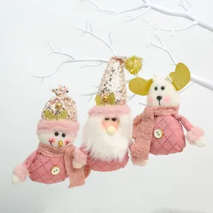 Set of three pink plush Christmas ornaments with sequin hats hanging on a white branch