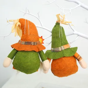 Close-up of two autumn faceless gnomes with pointed hats hanging on white branches