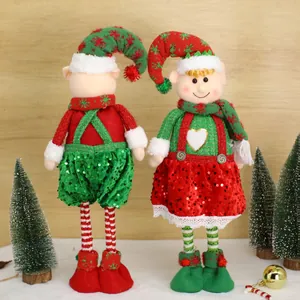 Feestelijk paar kerstelf knuffelpoppen met pailletten in een besneeuwde omgeving