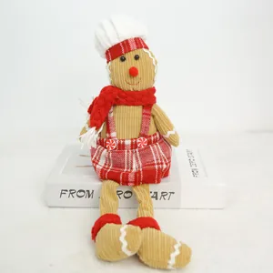 Close-up of a corduroy gingerbread man doll with a chef hat and red plaid Christmas outfit