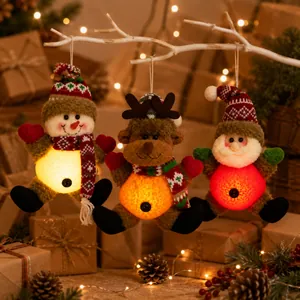 Close-up of glowing Santa, Snowman, and Reindeer plush Christmas tree hanging ornaments
