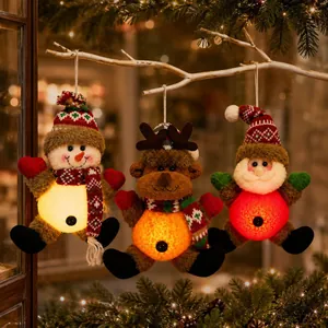 Three glowing Christmas plush ornaments with Santa, snowman and reindeer hanging on a branch.