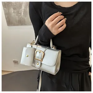 Trendy silver textured mini square handbag with gold buckle and matching pouch detail.