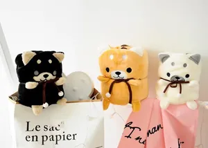 Vue détaillée de trois couvertures en peluche Shiba Inu roulées en noir, jaune et blanc