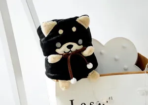 Vue détaillée d'une jolie couverture roulée en flanelle peluche Shiba Inu noir dans une boîte