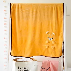 Détail de la couverture en flanelle jaune avec un motif de chien Shiba Inu en peluche 3D.