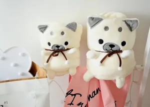 Gros plan de couvertures en flanelle roulées en forme d'adorables chiens Shiba Inu crème.