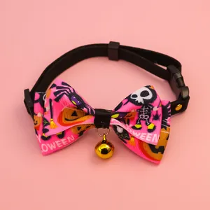Détail du collier d'Halloween pour animaux avec nœud rose, motifs crânes et clochette.