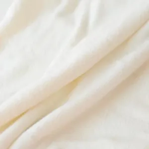 Gros plan d'une couverture en flanelle blanche douce montrant la texture pelucheuse