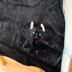 Gros plan détaillé d'une couverture en flanelle noire douce avec broderie chat