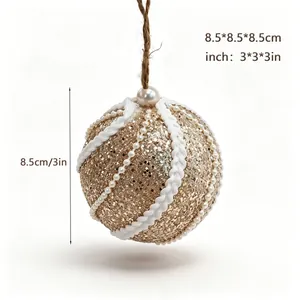 Detailansicht der Größe einer goldenen Weihnachtskugel mit Perlen und Seil.
