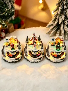 Detailed view of three glowing Christmas snow village music boxes with rotating trains.
