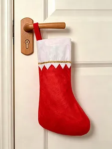 Red felt Christmas stocking decoration hanging on a wooden door handle