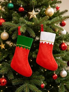 Pair of red festive Christmas stockings hanging on a decorated pine tree branch