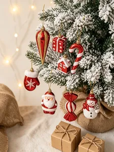 Set aus rot-weißen Weihnachtsanhängern mit Weihnachtsmann und Schneemann am Tannenbaum
