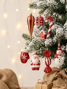Nahaufnahme von roten und weißen Weihnachtsanhängern an einem verschneiten Tannenbaum.