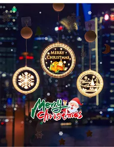 Close-up detail of three glowing LED Christmas window lights with festive patterns in night