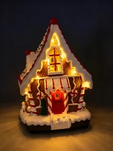 Primo piano di una casetta di pan di zenzero natalizia con luci LED e decorazioni di caramelle.