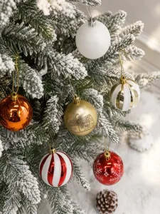 Nahaufnahme von dekorativen Weihnachtskugeln mit Schneeflocken- und Hausmustern am Baum