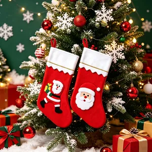 Lot de deux chaussettes de Noël rouges festives suspendues à un sapin décoré