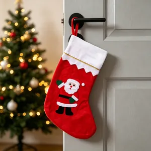 Chaussette de Noël en feutre rouge avec appliqué Père Noël suspendue à une porte