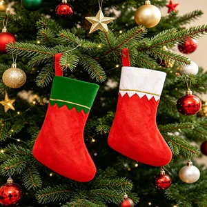 Pair of red and green festive Christmas stockings hanging on a decorated tree