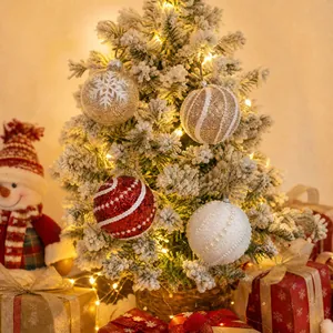 Dekoratives Set rote weiße goldene Weihnachtskugeln an beflocktem Baum mit Geschenken