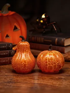 Detalle de lámparas de calabaza de cristal craquelado con luz cálida de Halloween