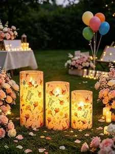 Tres velas LED decorativas con patrones de Happy Birthday y luces en un entorno de jardín