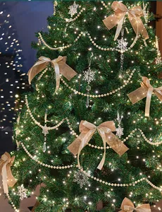 Detailed view of Christmas tree with burlap bows, pearl garlands and glowing lights