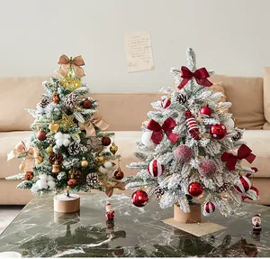 Decorated tabletop flocked Christmas trees with glowing lights for festive home decor