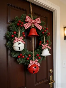 Gros plan d'une couronne de Noël festive avec des baies rouges et des cloches sur une porte.