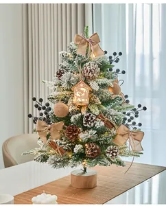 Detailed view of a lighted snowy mini Christmas tree with pine cones and burlap bows