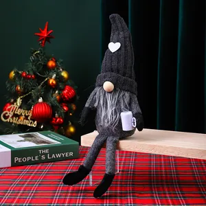 Vista detallada de un gnomo navideño de punto con piernas largas y taza de café.