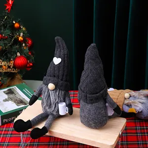 Detalle de gnomos navideños de punto gris sentados en soporte de madera con fondo festivo