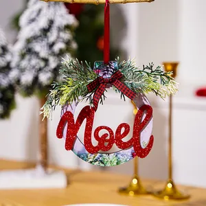 Close-up of wooden Christmas Noel ornament with red glitter finish and plaid bow
