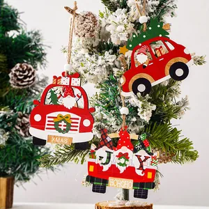 Detailansicht roter Weihnachtsanhänger aus Holz mit Zwergen an verschneitem Baum