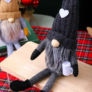 Primer plano de un gnomo de Navidad gris tejido a mano con piernas largas y un corazón