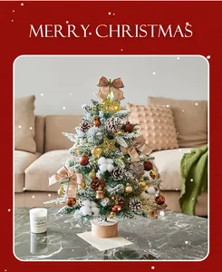 Detailed view of snow-dusted tabletop Christmas tree with glowing LED lights and ornaments.