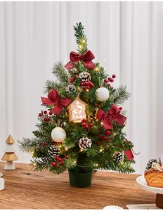 Detailed view of a pre-lit tabletop Christmas tree with red bows and pine cones
