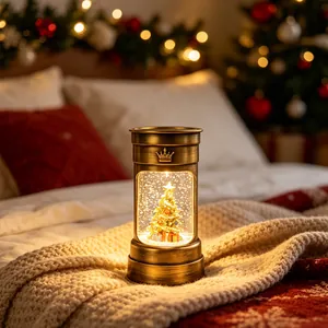 Lanterne de Noël vintage avec boule à neige et lumière LED chaude, finition bronze.