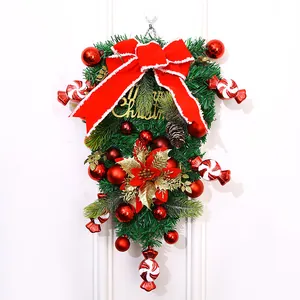 Detailansicht eines Weihnachts-Türhängers mit großer roter Schleife und Dekorationen