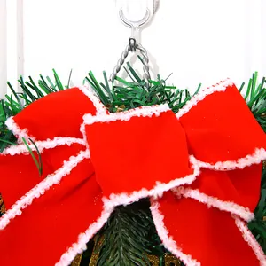 Detailansicht einer festlichen roten Samtschleife mit weißem Besatz auf einem Weihnachtskranz