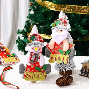Detailed view of Santa and Snowman Christmas plush ornaments with bells and JOY signs