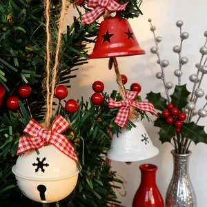 Cloches de Noël avec baies rouges et nœuds à carreaux suspendus à la branche