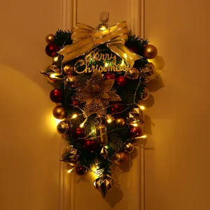 Nahaufnahme eines dekorativen Weihnachts-Türhängers mit goldener Schleife und LEDs