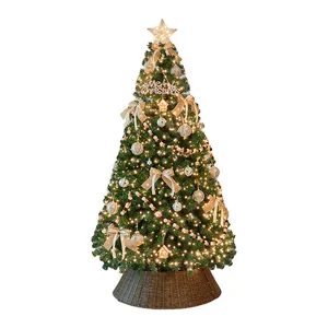 Albero di Natale decorato oro e marrone con luci e base in rattan su sfondo bianco