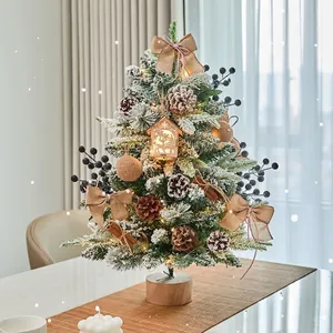 Snow-flocked tabletop Christmas tree with lights, pine cones, and wood base decor